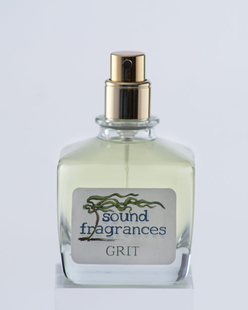 Grit perfume by Sound Fragrances, spicy Eau de Parfum bottle on gray background — artisan fragrance from the Pacific Northwest.