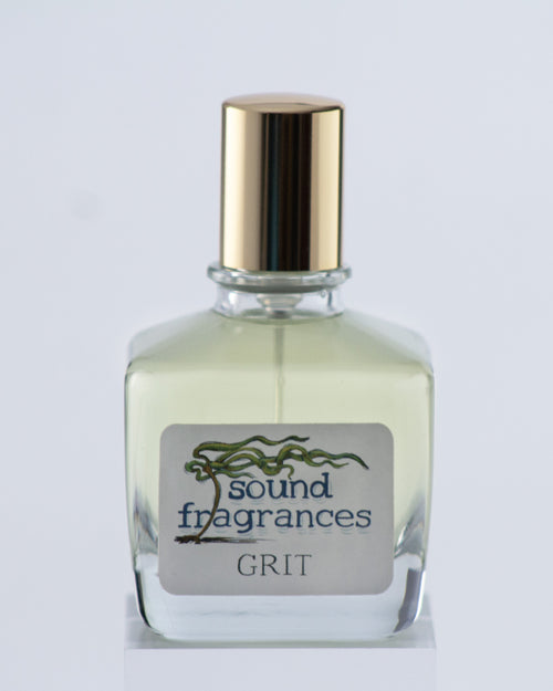 Grit perfume by Sound Fragrances, spicy Eau de Parfum bottle on gray background with gold lid — artisan fragrance from the Pacific Northwest.