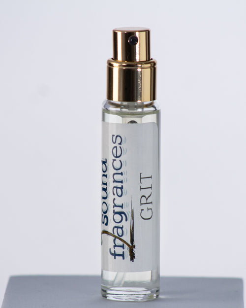 Grit perfume by Sound Fragrances, spicy Eau de Parfum travel bottle on gray background — artisan fragrance from the Pacific Northwest.