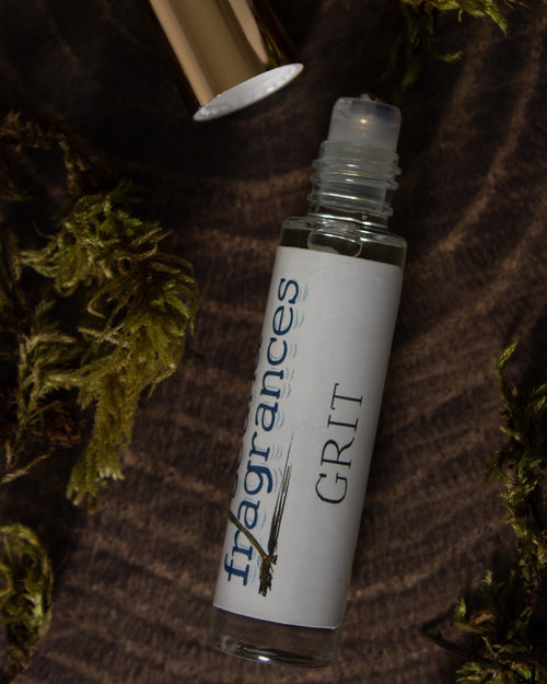 Grit perfume by Sound Fragrances, spicy Eau de Parfum mini bottle on wood surface with moss accents  — artisan fragrance from the Pacific Northwest.