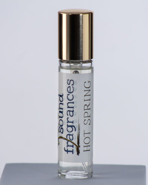 Hot Spring perfume by Sound Fragrances, thermal inspired Eau de Parfum travel bottle on gray background with gold lid — artisan fragrance from the Pacific Northwest.