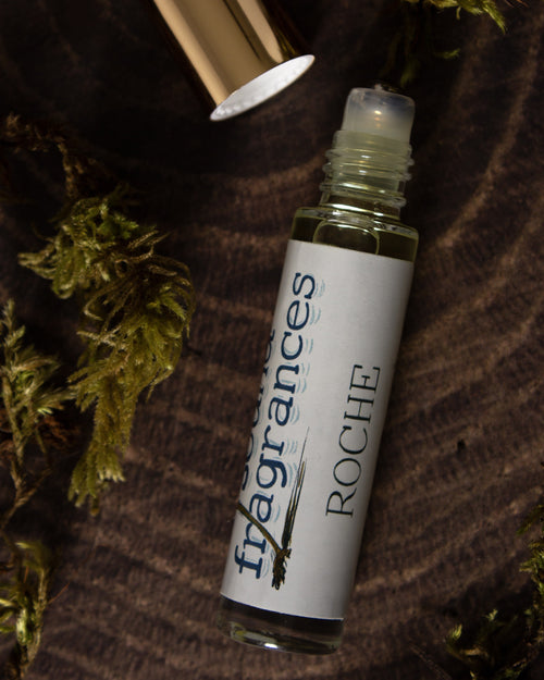 Roche perfume by Sound Fragrances, island inspired Eau de Parfum mini bottle on wood surface with moss accents  — artisan fragrance from the Pacific Northwest.
